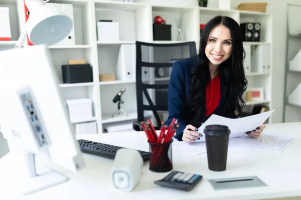 Schönes junges Mädchen arbeitet mit Computer und Dokumenten im Büro am Tisch. — Stockfoto