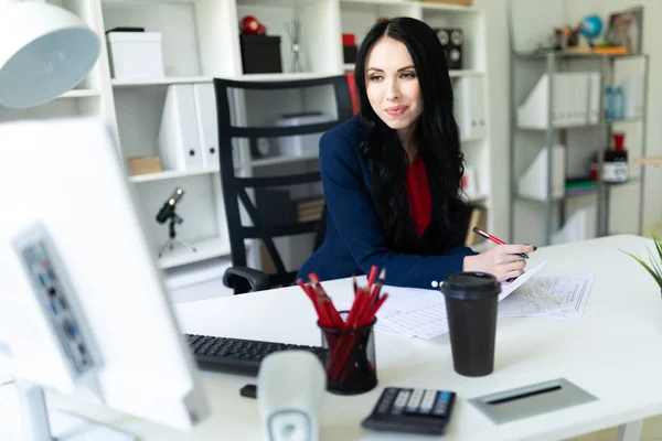 Krásná mladá dívka pracující s počítačem a dokumenty v kanceláři na stole. — Stock fotografie