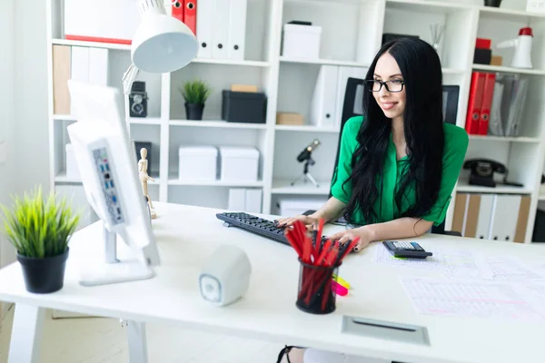 メガネの若い女の子は、コンピューター、電卓と書類が事務所で働いてください。. — ストック写真