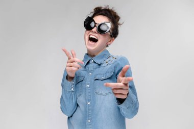 Siyah gözlüklü genç esmer kız. Kedi gözlük. Saç bir topuz toplanır. Dans kızı.