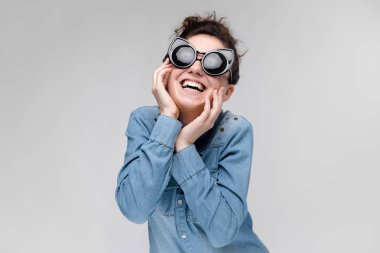 Siyah gözlüklü genç esmer kız. Kedi gözlük. Saç bir topuz toplanır. Kız onun yüzüne tutuyor.