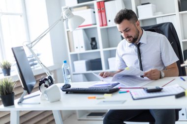 Bir adam ofiste masada oturan ve belgeleriyle çalışma.
