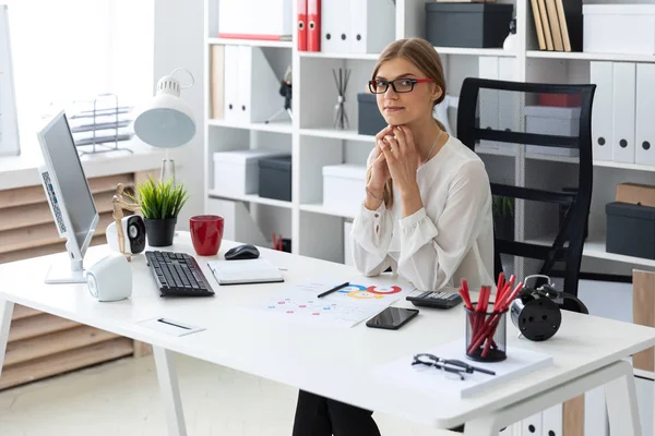 A young girl is sitting at the computer desk in the office. — Stock Photo, Image