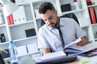 Bir adam oturuyor ve verilirse aracılığıyla belgeleri.