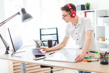 Bir genç adam gözlük ve kulaklık bilgisayar çalışıyor. Adam bir manyetik kurulu ve işaretleri olmadan.