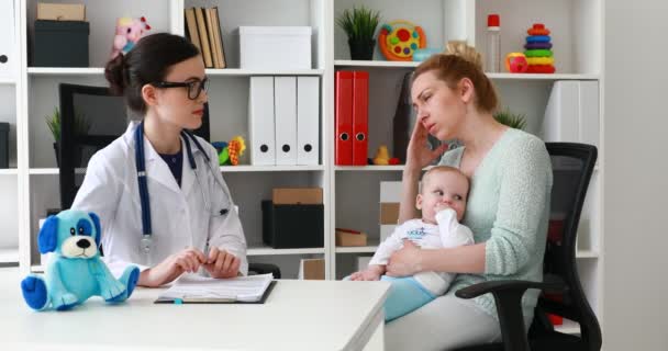 Μητέρα και τον μικρό γιο στον παιδίατρο. Γιατρός εξετάζει ασθενή λίγο — Αρχείο Βίντεο