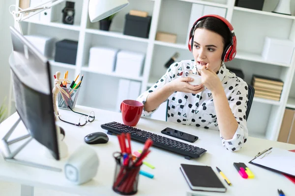 Kulaklık ofis masasında otururken, yoğurt yeme ve monitöre arıyorum güzel genç kız.