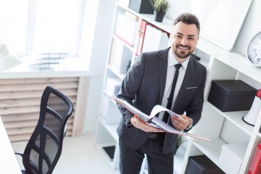 Sakallı bir adam bir takım elbise ile parlak bir ofiste çalışıyor. alan derinliği ile fotoğraf.