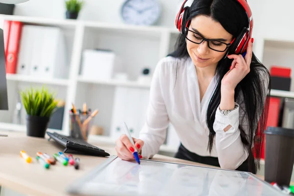 Genç bir kız kulaklık tablo anlamına gelir ve bir işaretleyici manyetik bir tahtaya çizer.