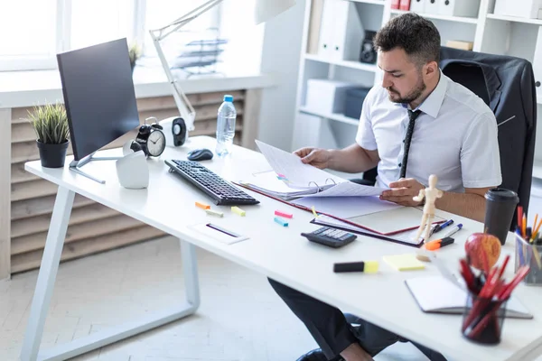 Bir adam oturuyor ve verilirse aracılığıyla belgeleri.