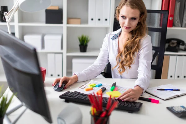 Güzel genç kız masa ofis oturma ve bilgisayarda çalışan. Hoşlandığın kızın önünde belgeleri vardır.