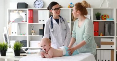 Yalan ve masada oynama ve tedavi tartışırken Doktor muayene bebek ile anne