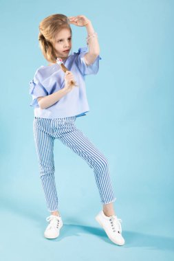 Mavi arka planda mavi elbiseli güzel bir kızın tam boy portresi..