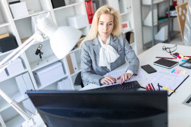 Genç kız ofiste bilgisayar ve belgeler ile çalışma.