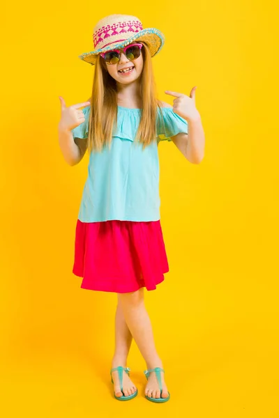 Ragazza con i capelli rossi su sfondo giallo. Affascinante ragazza in abiti estivi luminosi mostra le dita su di sé . — Foto Stock
