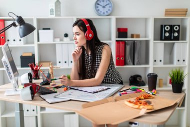 Genç bir kız bir masanın ayakta, yeşil kalem tutan ve ekrana bakarak. Önce kız masanın üzerinde manyetik bir pansiyondur. Kulaklıklar giyen kız kafasına.