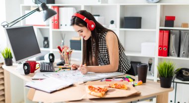 Genç bir kız bir tablo duruyor, turuncu bir işaret onun elinde tutan ve manyetik tahtaya benziyor. Kulaklıklar giyen kız kafasına.