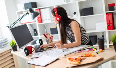 Genç bir kız bir tablo duruyor, turuncu bir işaret onun elinde tutan ve ekrana görünüyor. Kulaklıklar giyen kız kafasına.