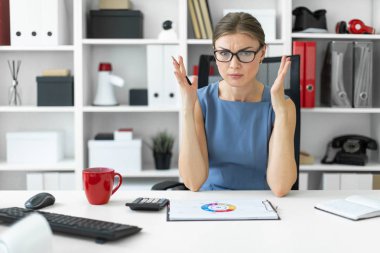 Genç bir kız ofiste bir masada oturur ve bir belgeyi içeren bir grafik görünüyor.