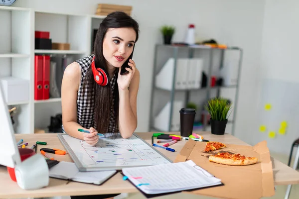 Genç bir kız bir masanın ayakta, yeşil bir işareti onun elinde tutan ve Evet. Kızlar kulaklık boynuna asmak.
