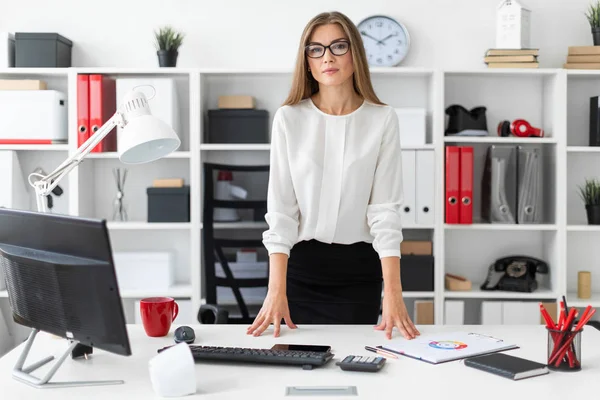 Genç bir kız ofiste bir tabloda yakınındaki duruyor.