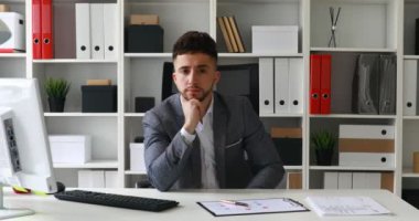 Beyaz ofis masada oturan ve elini alnına koyarak yönetmen