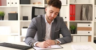 işadamı beyaz ofis masada oturan ve belgeler üzerinde yazma takım elbise ceket