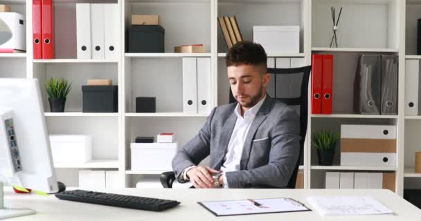 Junger Geschäftsmann Anzug Sitzt Tisch Weißen Büro Schaut Auf Die — Stockvideo
