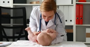 masanın üzerinde yatan çocuk ile oynayan çocuk doktoru