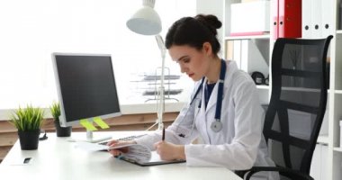 belgeleri doldurma ve kameraya bakarak genç doktor