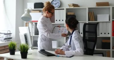 Doktorlar ofiste programları kağıt üzerinde tartışıyorlar.