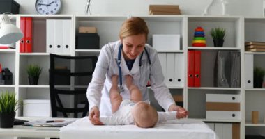 Masaya yeni doğan bebekle yordamları gerçekleştirirken çocuk doktoru