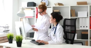 Kadın doktorlar ofiste belgelerle çalışıyorlar.