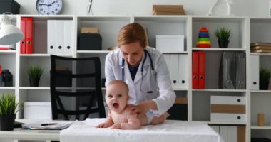 Masaya yeni doğan bebekle yordamları gerçekleştirirken çocuk doktoru