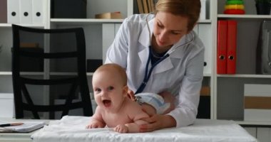 Masaya yeni doğan bebekle yordamları gerçekleştirirken çocuk doktoru