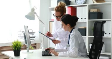 Kadın doktorlar ofiste belgelerle çalışıyorlar.
