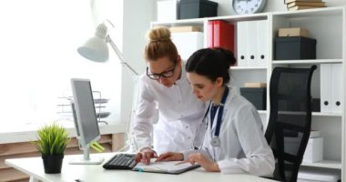 Kadın doktorlar ofiste belgelerle çalışıyorlar.