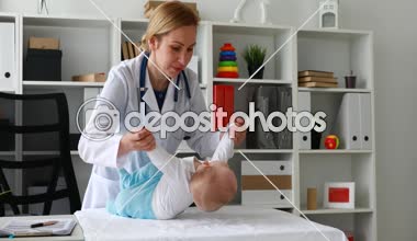 Masaya yeni doğan bebekle yordamları gerçekleştirirken çocuk doktoru