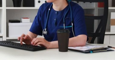 İşyerinde oturan ve bilgisayarda çalışan doktor görüntü kırpılmış