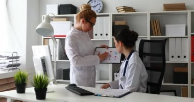 Doktorlar ofiste programları kağıt üzerinde tartışıyorlar.