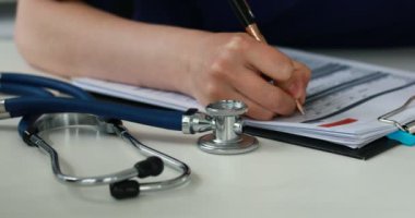 Bir doktor kağıtları stetoskop, yakın çekim doldurma kırpılmış görüntü