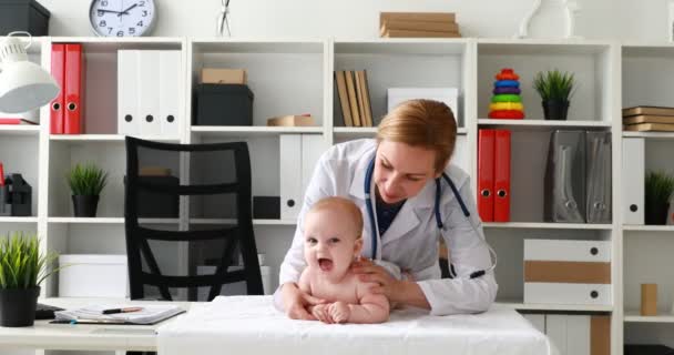 儿科医生执行程序与新生儿在桌上 — 图库视频影像