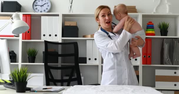 Pediatra Sosteniendo Bebé Brazos Mirando Cámara — Vídeo de stock
