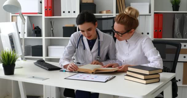 Doctores Mujeres Leyendo Libro Oficina — Vídeos de Stock