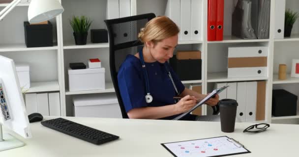 Dokter Maken Van Aantekeningen Documenten Camera Kijken — Stockvideo