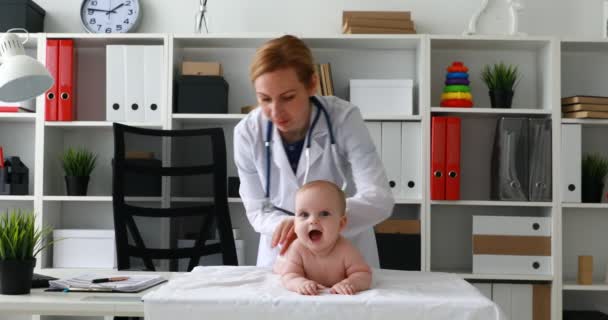 Kinderarzt Massiert Rücken Eines Auf Tisch Liegenden Kindes — Stockvideo