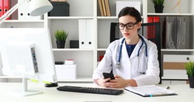 İşyerinde smartphone kullanarak beyaz önlük doktor