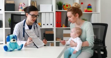 Doktor tanı için dinleme elinde bebekle anne