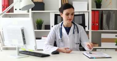 İşyerinde oturan ve belgeleri okuma beyaz önlük doktor