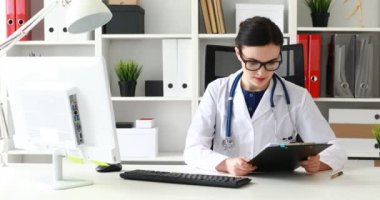 belgeleri okuma ve gözlükleri çıkar atıyor ve kameraya bakarak doktor